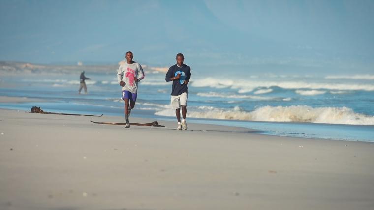 Two men running on the beach